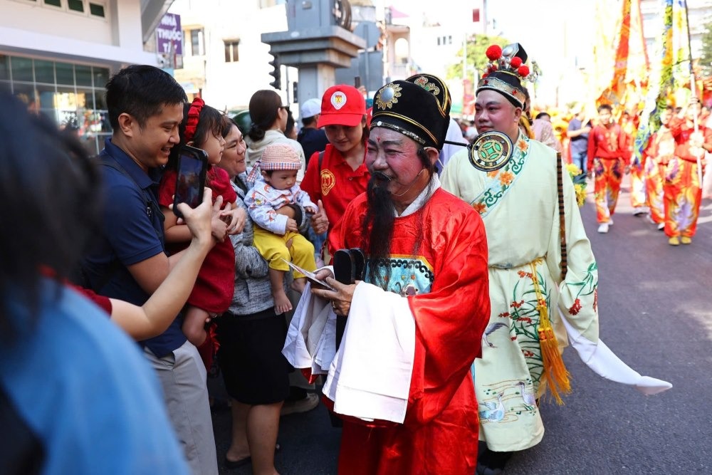 Đông người dân đứng dọc hai bên đường để chào mừng, cầm theo nhang, chắp tay cầu nguyện khi đoàn rước tượng Quan Công đi ngang qua để lấy vía may mắn, tài lộc đầu năm.